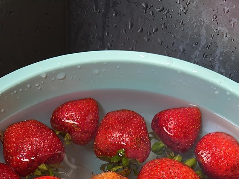 strawberries in pink water after PurePod cleaning